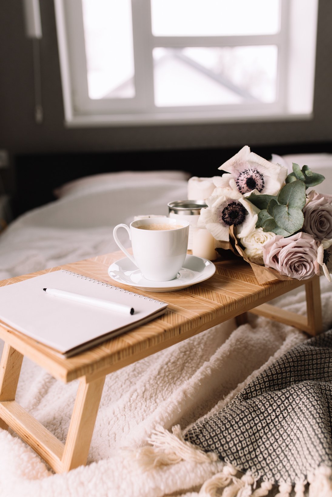 Brown Coffee Table with Flowers and Notebook on the Bed